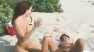 Two lesbians finger and lick each other on the beach
