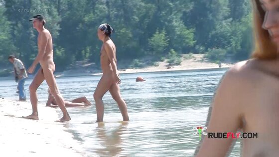 Playful blond nudist teen caught on camera naked at the beach