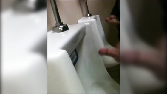 two slim dicks getting wanked at the urinals